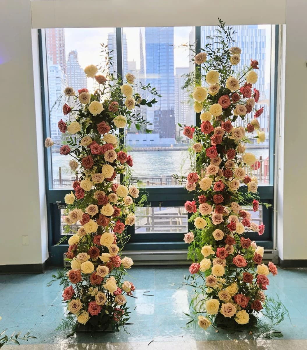 A pair of cream and coral rose columns framing a riverside window